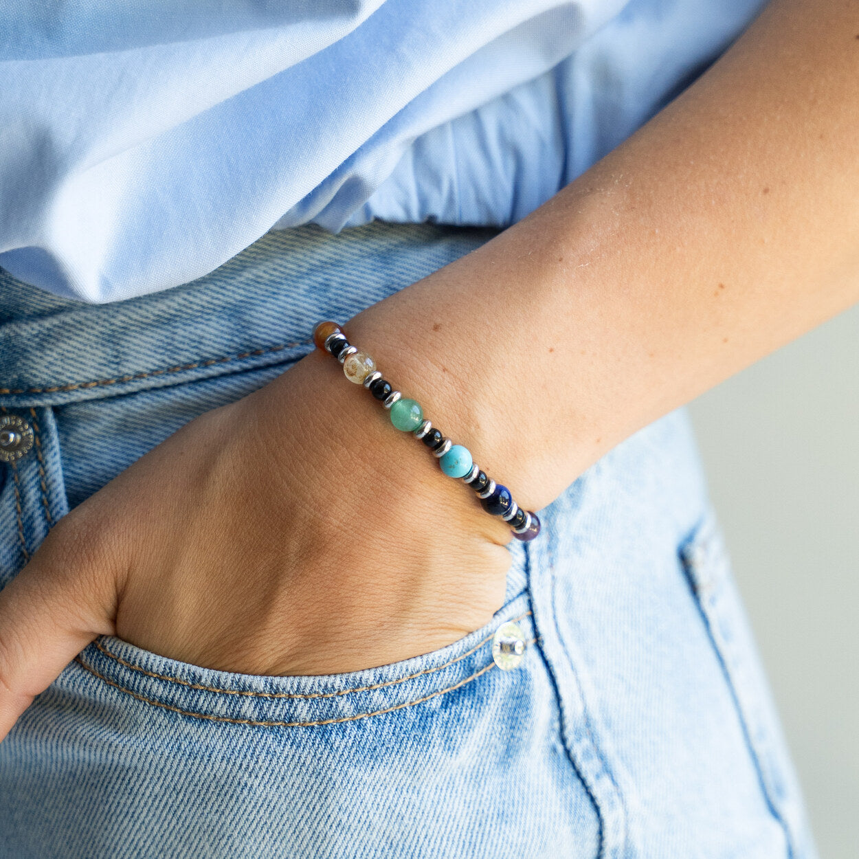 Bracciale artigianale Chakra indossato al polso con mano in tasca, Lab93Studio