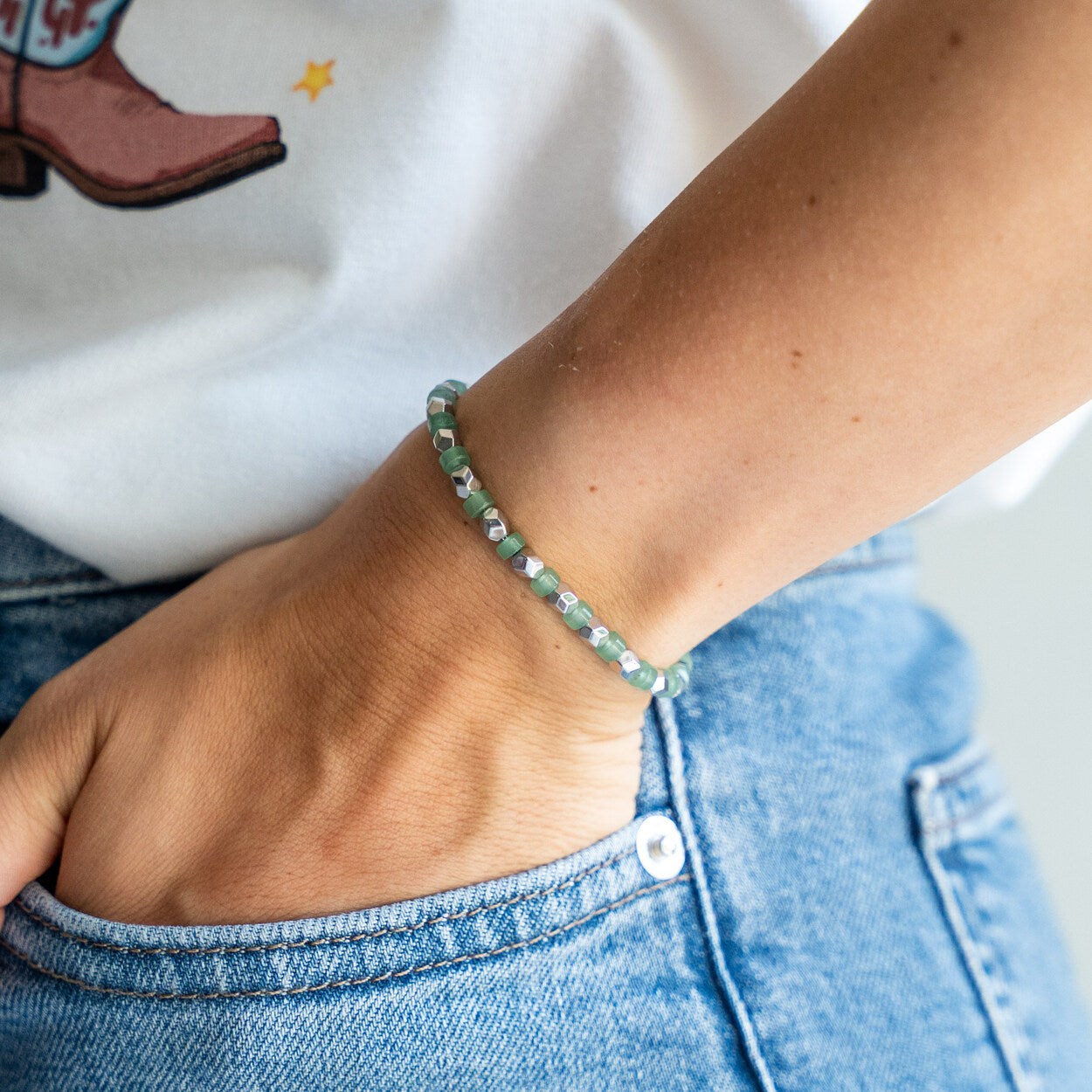 Bracciale artigianale donna Venere indossato al polso con mano in tasca, Lab93Studio