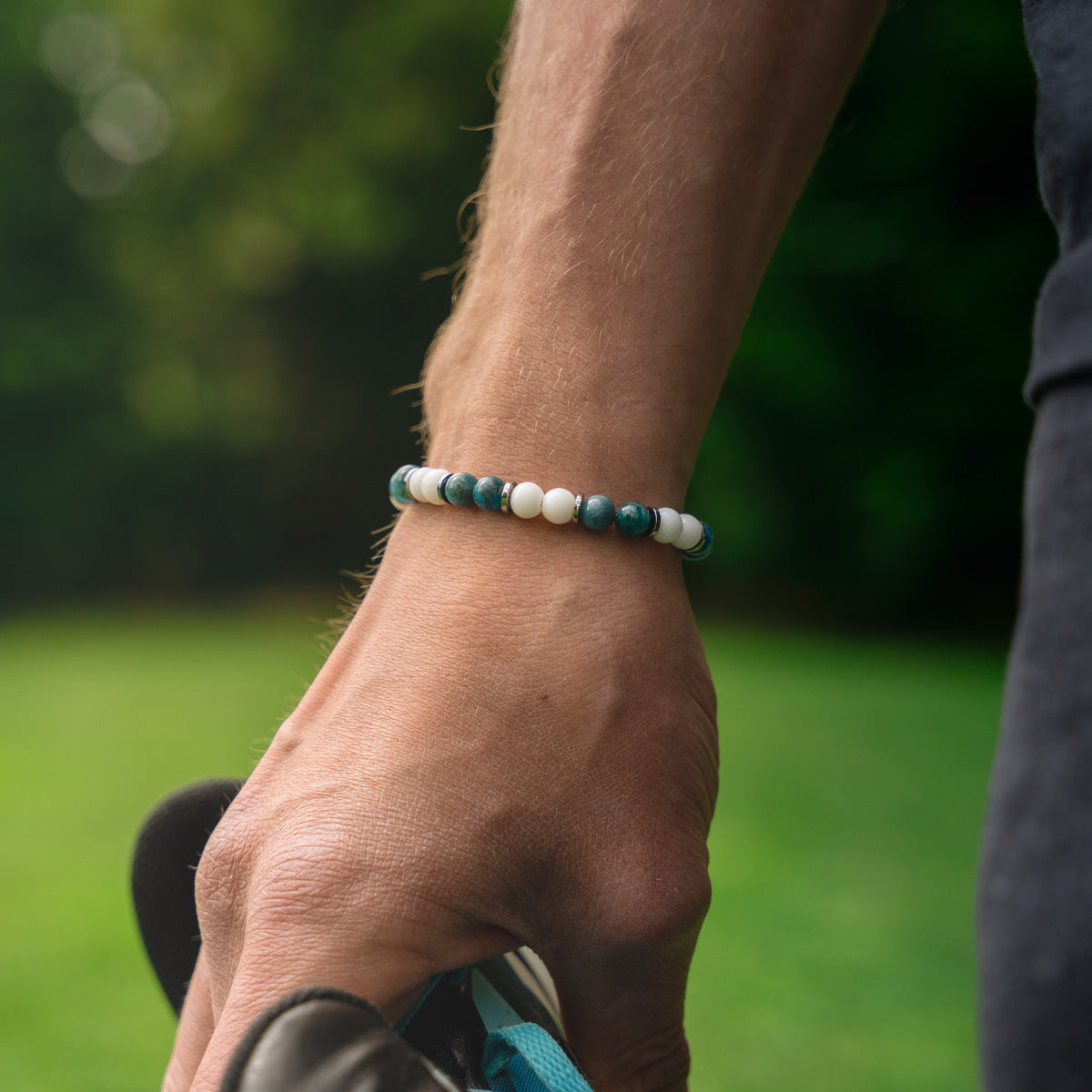 Bracciale artigianale da uomo indossato. Realizzato con agata bianca e apatite azzurra. Lab93Studio