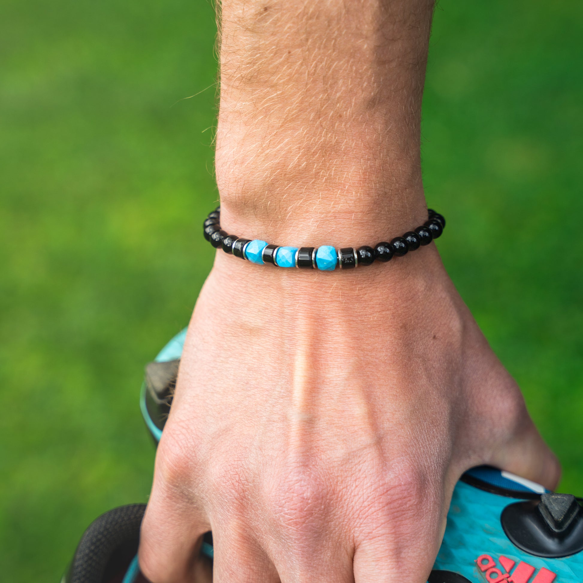 Bracciale artigianale da uomo indossato. Realizzato con onice nero, agata nera e aulite turchese/azzurra. Lab93Studio