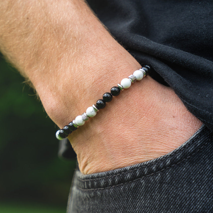 Bracciale artigianale da uomo indossato. Realizzato con aulite bianca e onice nero. Lab93Studio