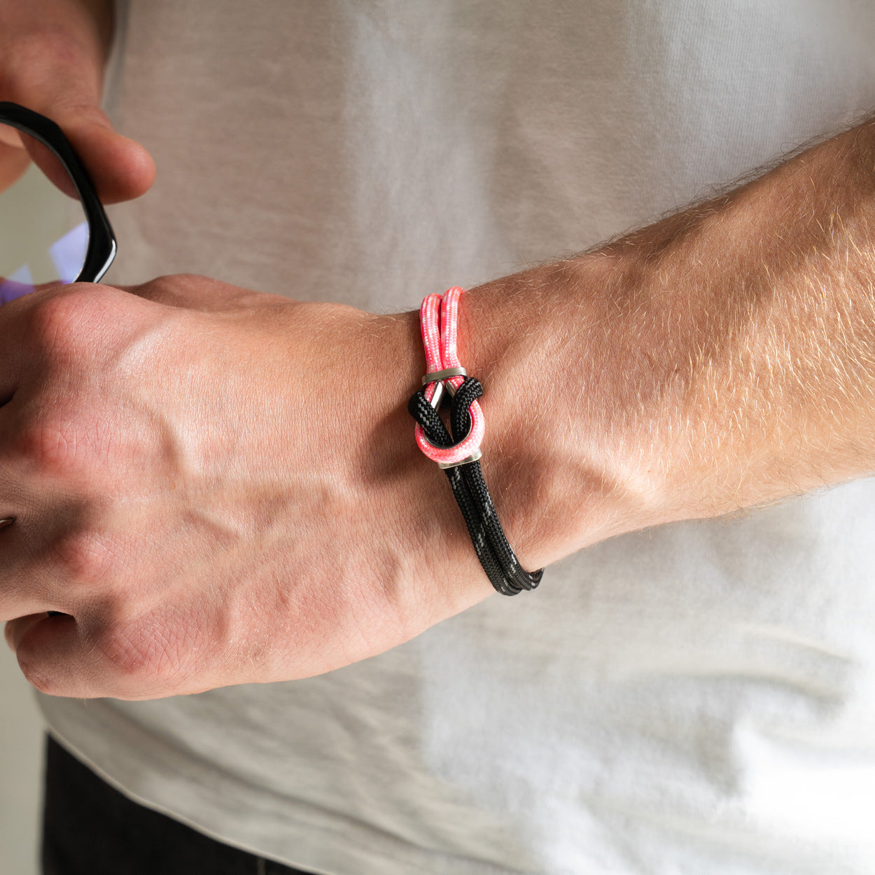 Bracciale Portofino Aliseo in paracord rosa e nero, dettaglio chiusura in acciaio indossato al polso, Lab93Studio