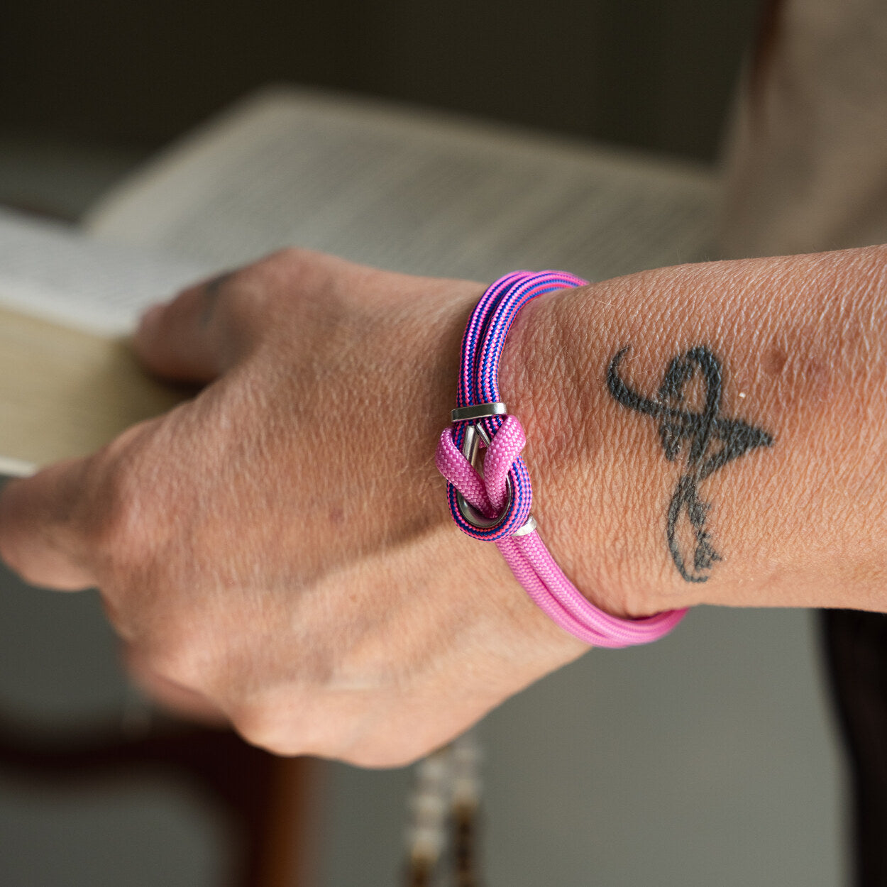 Bracciale Portofino Arena in paracord rosa e viola indossato al polso con tatuaggio, Lab93Studio