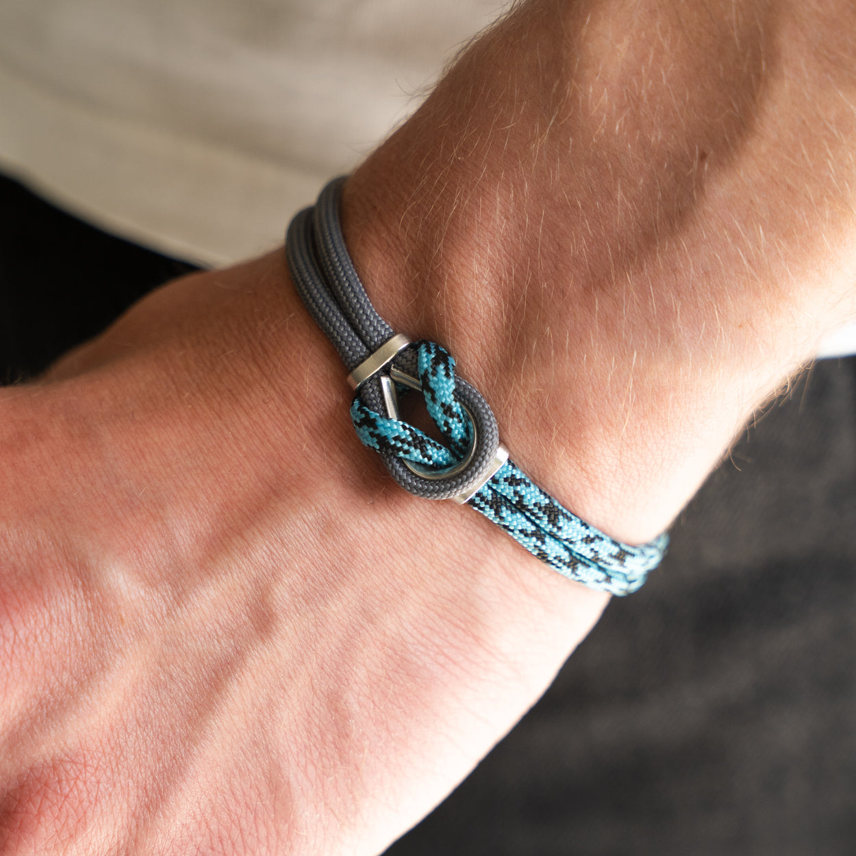 Bracciale Portofino Orione in paracord grigio e blu, dettaglio chiusura in acciaio indossato al polso, Lab93Studio