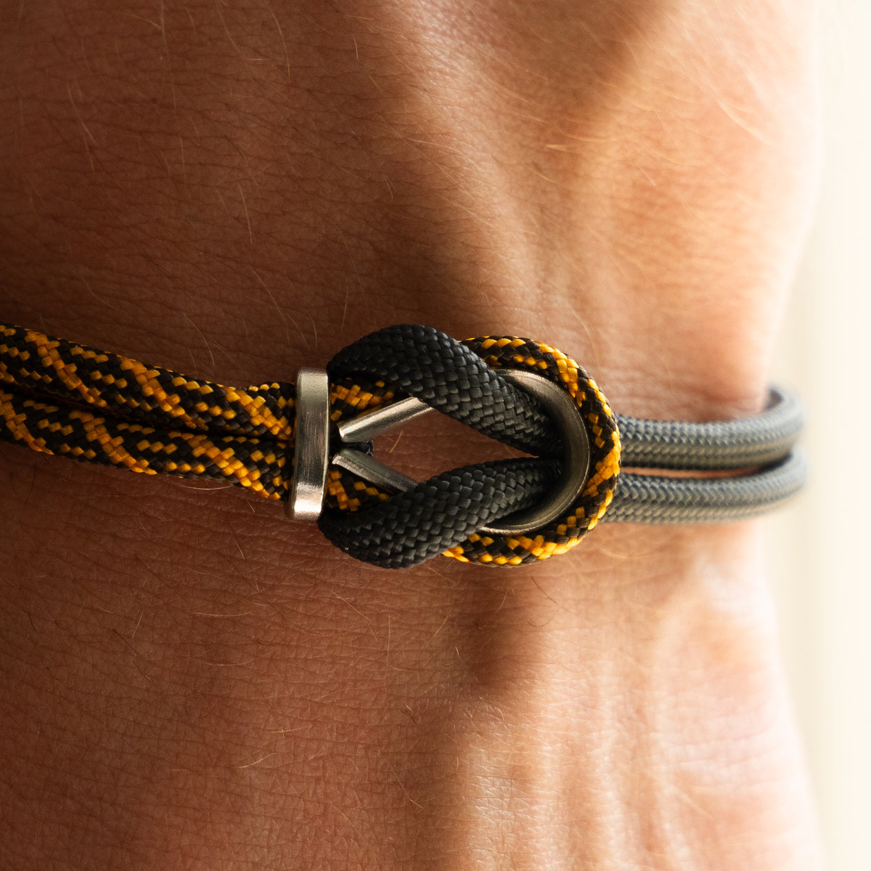 Bracciale Portofino Roccia in paracord giallo e nero indossato al polso destro, Lab93Studio
