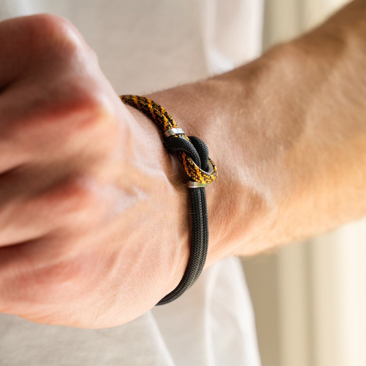 Dettaglio nodo bracciale Portofino Roccia in paracord giallo e nero indossato al polso, Lab93Studio