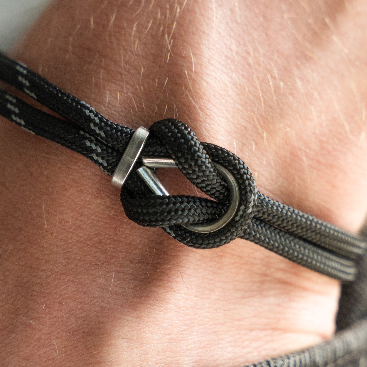 Dettaglio nodo bracciale Portofino Ulisse in paracord grigio antracite indossato al polso, Lab93Studio