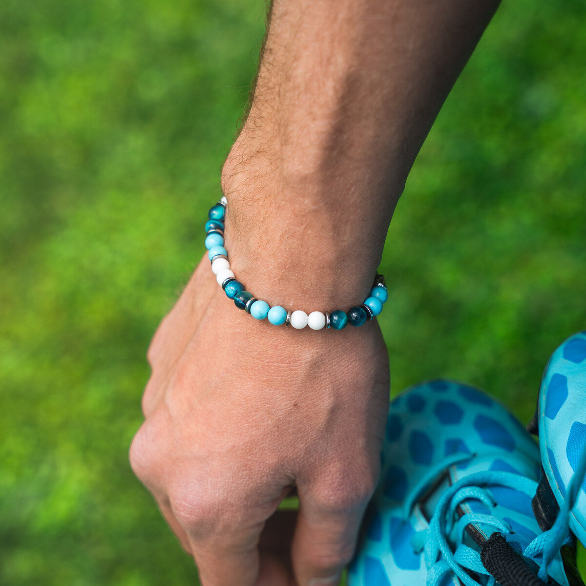 Bracciale artigianale da uomo indossato. Realizzato con occhio di tigre blu, agata bianca e aulite azzurra. Lab93Studio