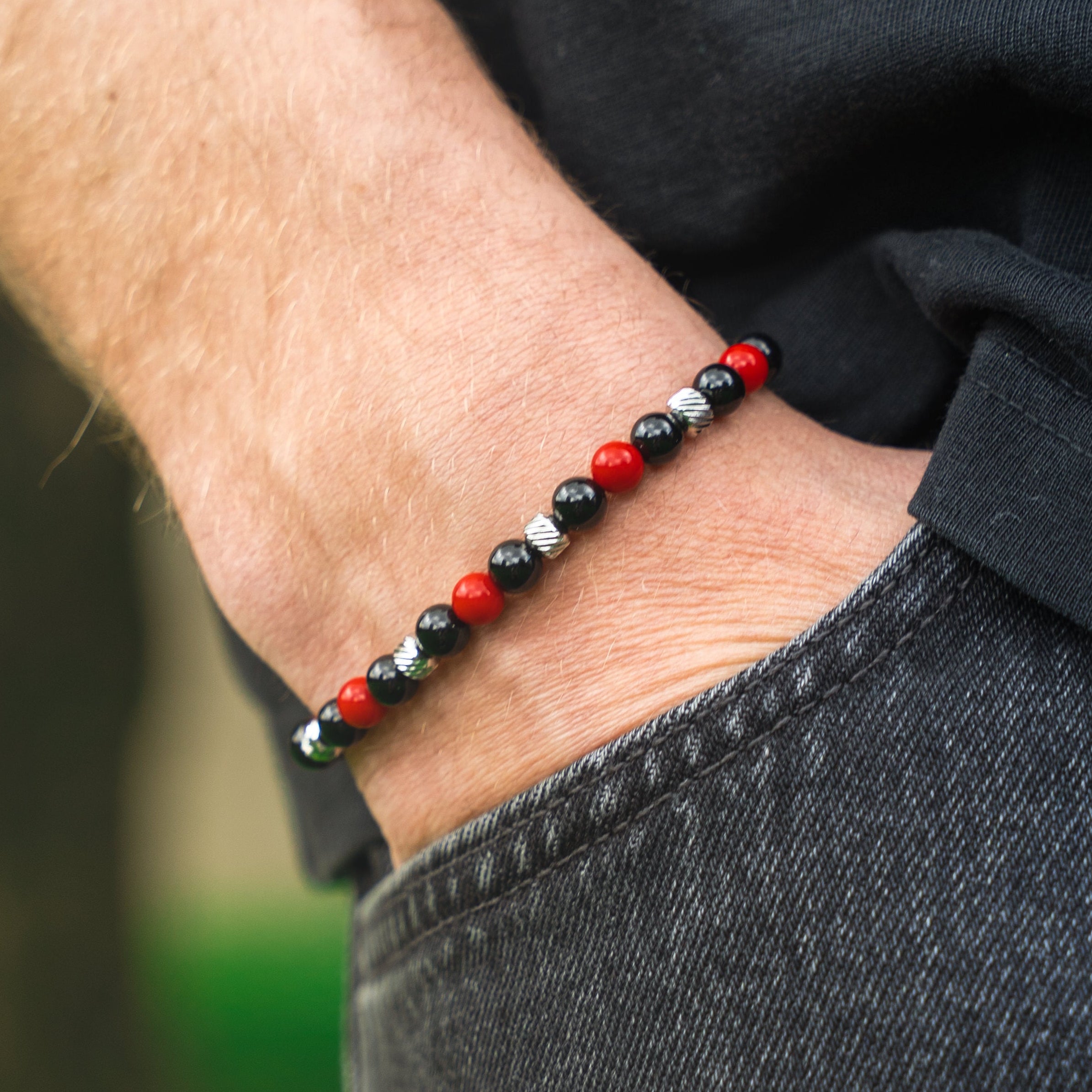 Bracciale artigianale da uomo indossato. Realizzato con onice nero e corniola rossa. Lab93Studio