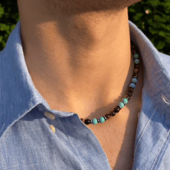 Collana Respiro Mediterraneo artigianale in aulite turchese e occhio di tigre indossata con camicia, Lab93Studio