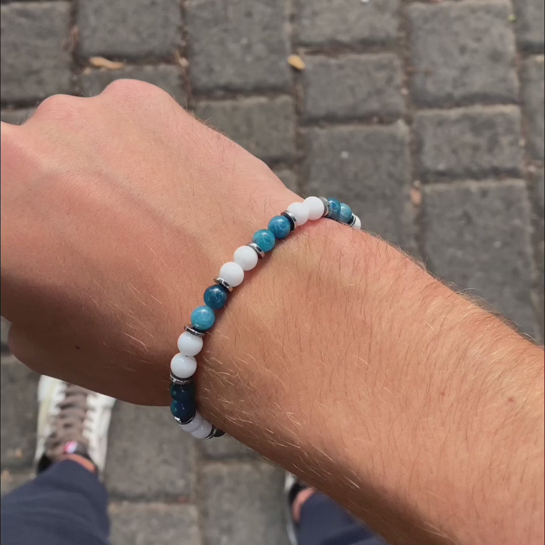 Carica video: Bracciale artigianale da uomo su prato. Realizzato con agata bianca e apatite azzurra. Lab93Studio