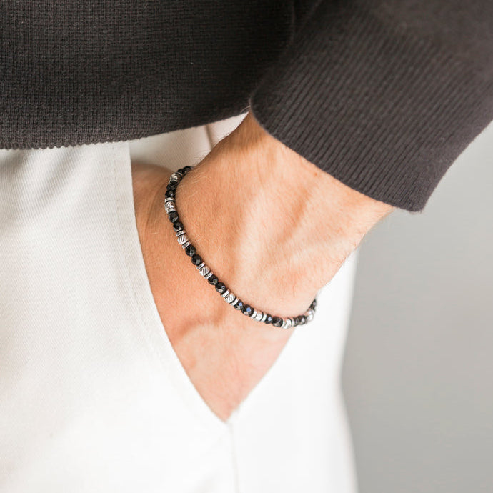 Bracciale Destino in onice nera indossato al polso con giacca scura, Lab93Studio